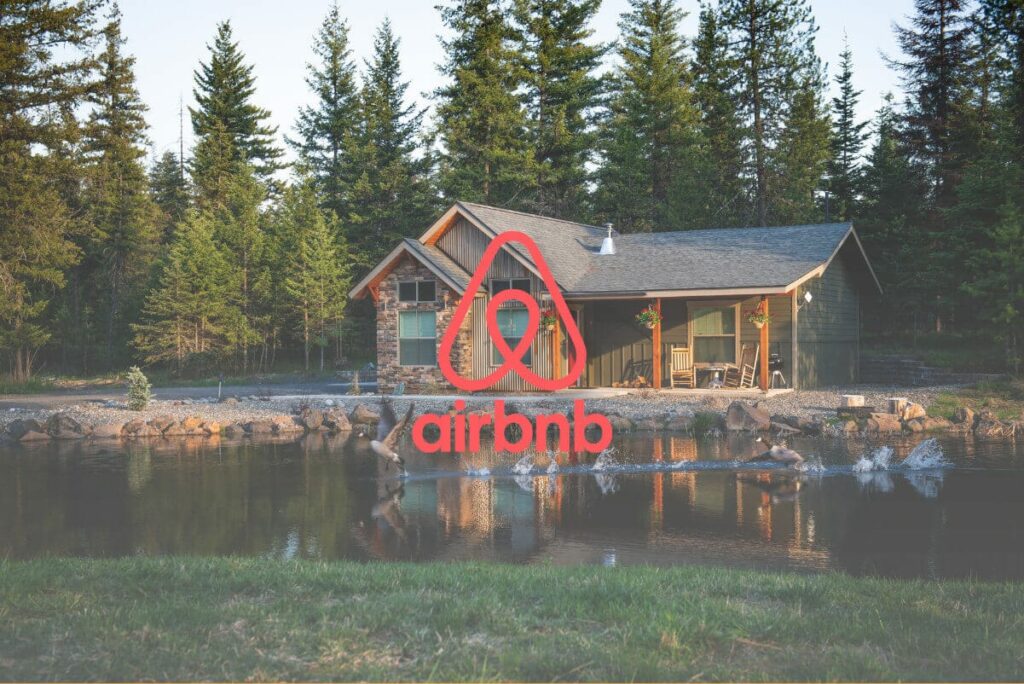 airbnb logo bovenop een foto van een airbnb aan het meer