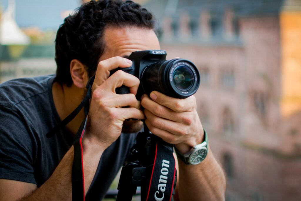 Een man met een camera klaar om een foto te nemen in close up - Je huis verhuren op Airbnb blog