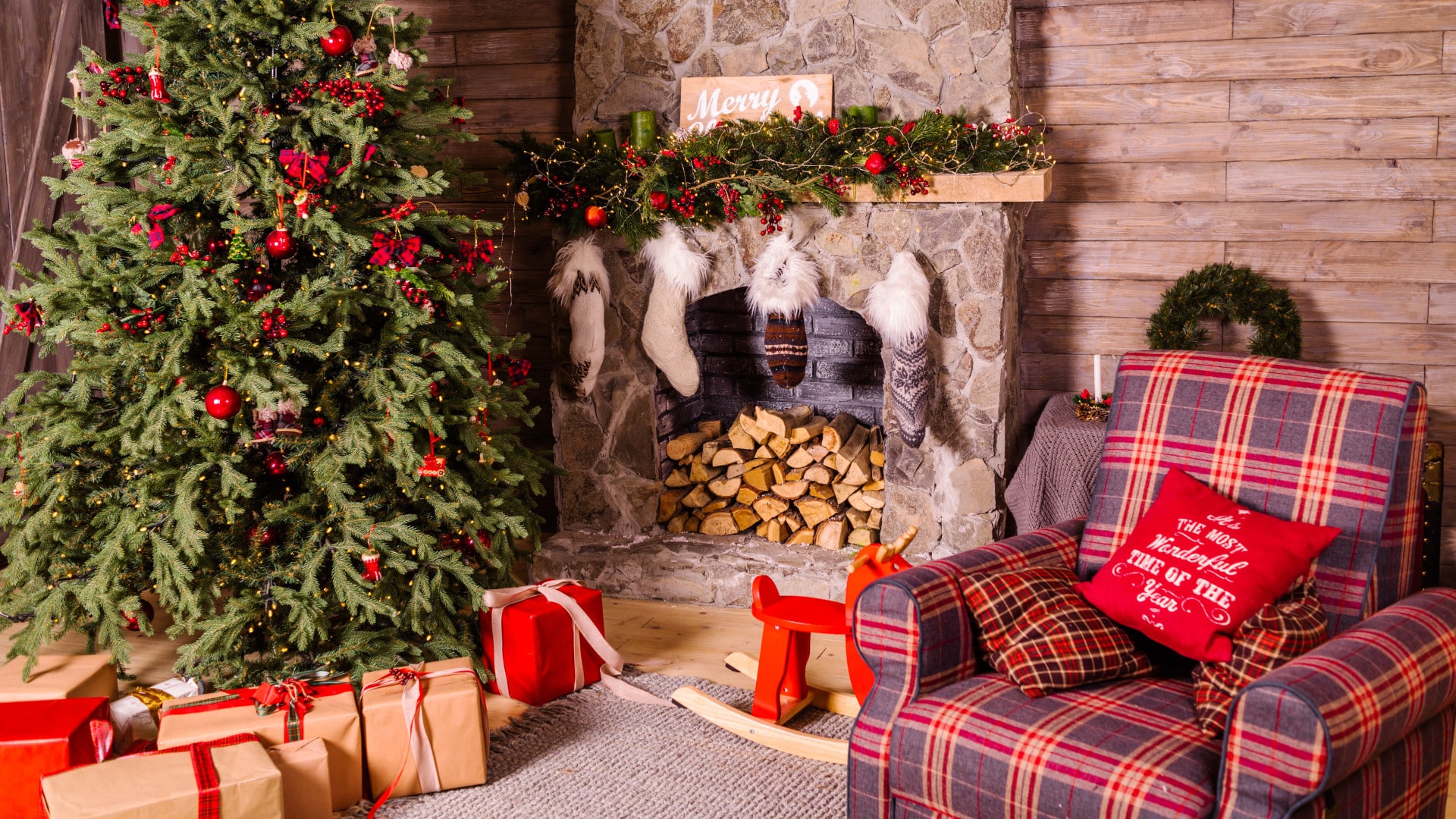 Gezellige woonkamer met een rode sofa en een kerstboom naast de openhaard